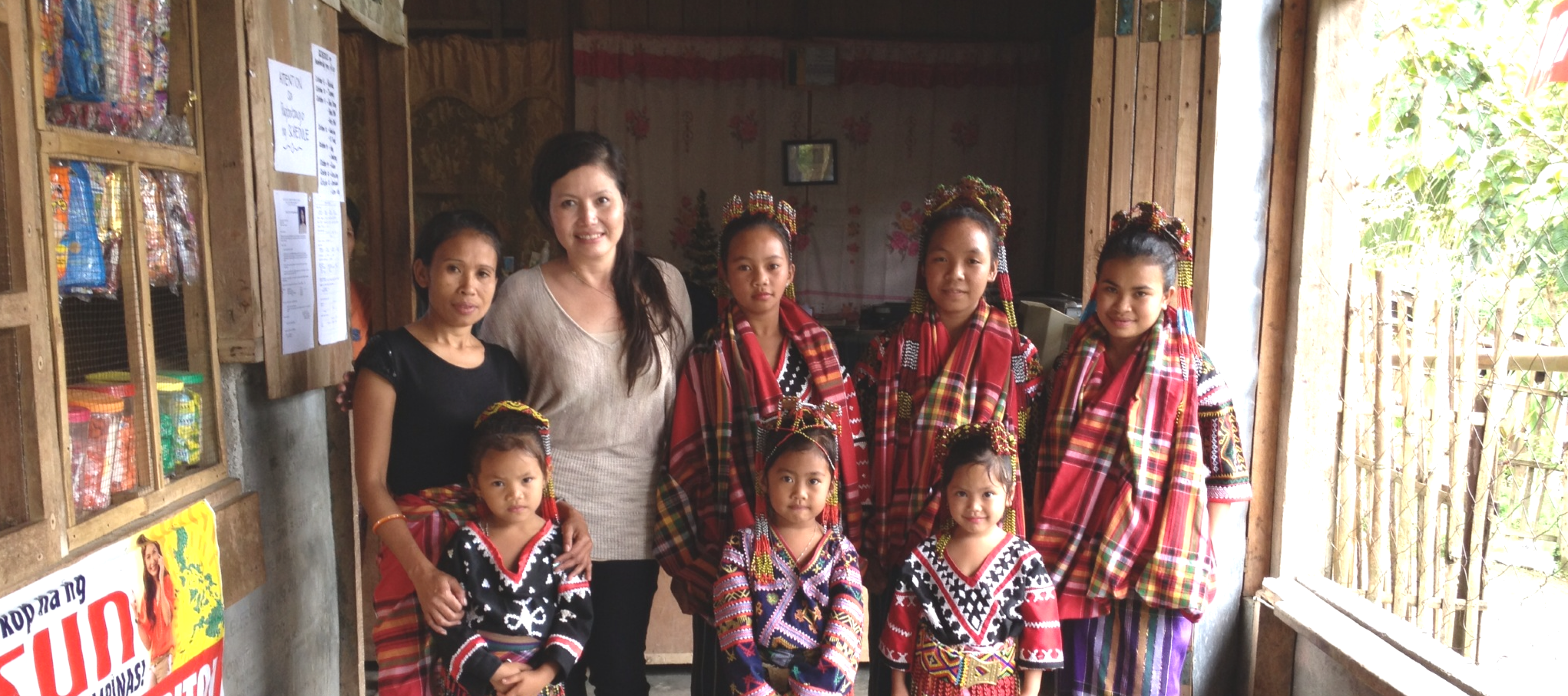 A photo of the founder of Four Truffles with a group of four young women and three young girls of The T’boli Tribe in the Philippines